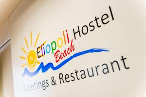 蒂勒尼亚Eliopoli Beach Hostel & Restaurant的医院主办的会议和餐厅的标志
