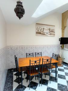 马拉喀什Les Riads Nour Resorts- Marrakesh Escape的一间带木桌和椅子的用餐室