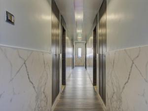 维杰亚瓦达V Hotel的一条带白色大理石墙壁和长走廊的走廊