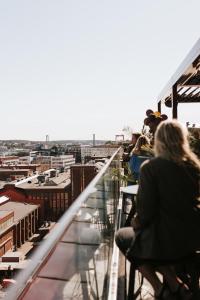 哥德堡Clarion Hotel The Pier的一群人坐在一个俯瞰城市的阳台