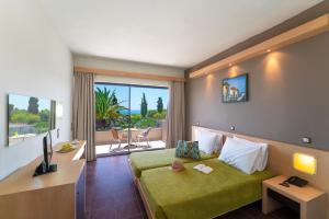 法里拉基凯瑟琳酒店的酒店客房设有一张绿色的床和一个阳台。