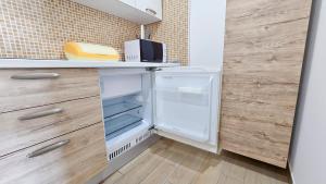 罗萨诺Aparthotel Codex的厨房配有开放式冰箱和木制橱柜。