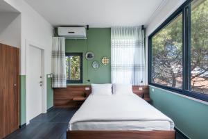 海法Carmel Suites by Olala Homes的一间卧室设有一张床和一个大窗户