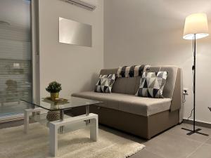 维罗维蒂察Apartman Panonica的带沙发和玻璃桌的客厅