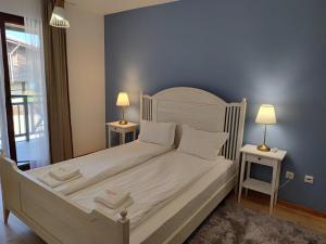 索佐波尔Sozopolis Holiday Village的卧室配有一张带两张桌子的大型白色床