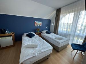 亚斯塔尔尼亚Villa REJS Jastarnia的一间卧室设有两张床和蓝色的墙壁