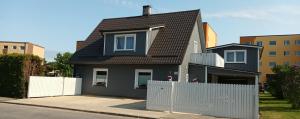 哈普萨卢Liisu Külalistemaja的一间黑色的小房子,设有白色的围栏