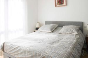巴黎Cocon lumineux proche de la Place de la Nation的一张白色的床,上面有两个枕头
