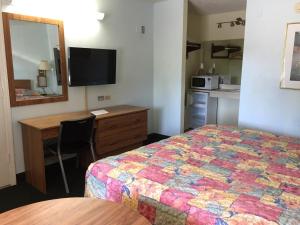 基西米弗拉明戈酒店的酒店客房带一张床、一张书桌和一面镜子