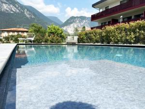 加尔达湖滨Residence Zangirolami - Luxury Garden and Balcony Apartments的一座山楼前的游泳池