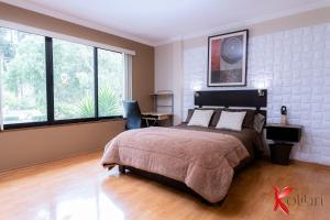 昆卡Hostal Kolibri B&B的一间卧室设有一张大床和大窗户
