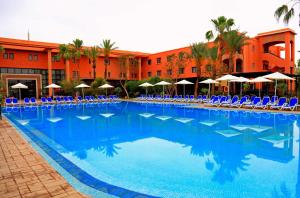 马拉喀什拉布兰达塔加水上公园酒店的一个带蓝色椅子和遮阳伞的大型游泳池