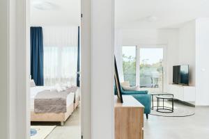 乌马格Apartments San Maris 2的一间卧室配有一张床、一张沙发和一台电视。