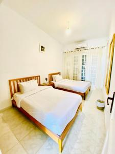 阿莱曼Marina Hills Residence的卧室设有2张床和白色的墙壁。