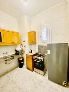 阿莱曼Marina Hills Residence的厨房配有黄色橱柜和不锈钢冰箱