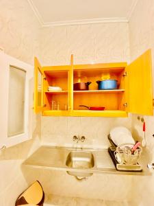 阿莱曼Marina Hills Residence的厨房配有黄色橱柜和水槽
