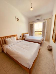 阿莱曼Marina Hills Residence的一间卧室设有两张床和窗户。