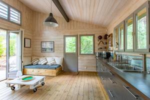 雷日卡普费雷Charmante maison en bois avec piscine dans les pins à la pointe的一间厨房和客厅,位于一个小房子里