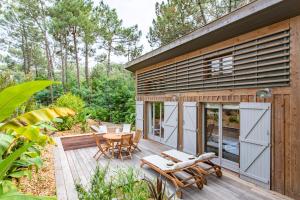 雷日卡普费雷Charmante maison en bois avec piscine dans les pins à la pointe的房屋设有1个带桌椅的甲板