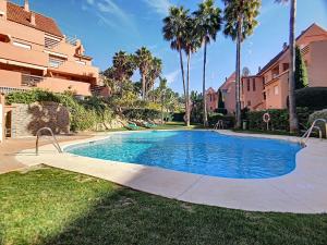 卡萨雷斯2231 - Amazing 3 bedrooms with 3 sunny terraces的棕榈树庭院内的游泳池