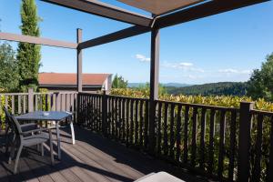 Faugères in Rhone-AlpesDomaine de Chalvêches Hôtel SPA 4*的美景甲板上配有桌椅