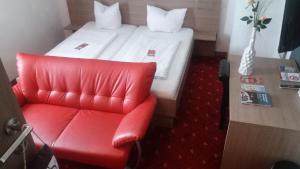 施特劳宾加斯霍夫法尔特旅馆的红色椅子和一张位于房间里的床