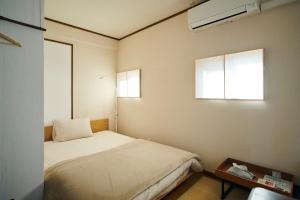 奈良琥珀旅舍的一间小卧室,配有床和窗户