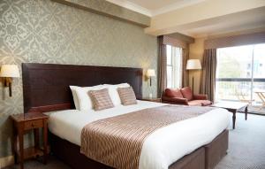 塞特福德Bell by Greene King Inns的酒店客房带一张大床和一把椅子