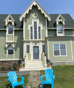 皮克图Seabank House Bed and Breakfast Aloha的两把蓝色椅子在房子前面