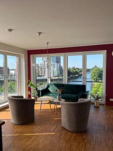 奥尔登堡Penthouse-Wohnung mit Flussblick的客厅配有椅子和桌子,设有窗户