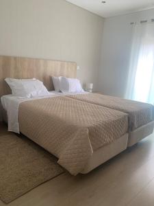 法蒂玛Apartamento Fátima Sanctuary的卧室配有一张带白色床单和枕头的大床。