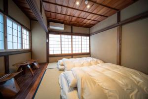 TakahashiCastle Town Contemporary Ryokan 天籟 - TENRAI -的一间卧室设有一张大床和两个窗户。
