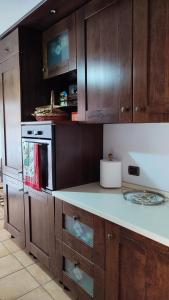 罗马Montagnola House的厨房配有木制橱柜和白色台面