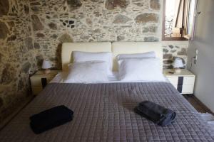 AmigdhalokeFálionAlegria stone house的一间卧室,配有一张带两个袋子的床