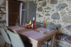 AmigdhalokeFálionAlegria stone house的一张木桌,上面放着一碗香蕉和一瓶葡萄酒