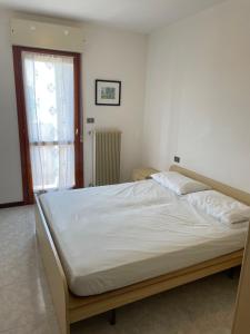 卡奥莱Duca degli Abruzzi的卧室配有一张带白色床单的大床和窗户。