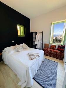 迈伊斯蒂Blue Horizon Kastellorizo的卧室配有一张白色的床和黑色的墙壁