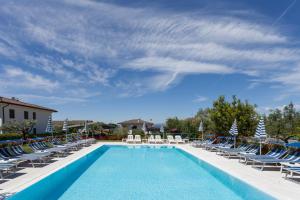 巴多利诺卡马萨瓦尔撒酒店的一个带躺椅的游泳池以及度假村