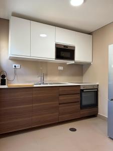加亚新城House Real Companhia的厨房配有白色橱柜、水槽和微波炉