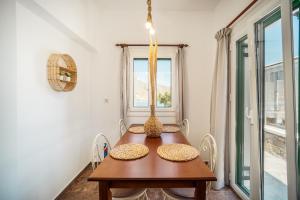 利瓦迪奥Astrio Suites的一间带木桌和窗户的用餐室