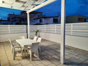佩斯科勒海滨Casa vacanze Pescoluse的夜间阳台上的桌椅