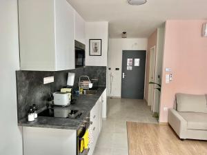 布达佩斯MM D Home Apartment的厨房配有白色橱柜和台面