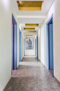 托隆Hotel Assini Beach Tolo的走廊上设有蓝色门,墙上挂着一幅画