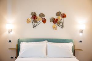 陶尔米纳DONNA FRANCA的卧室配有一张墙上鲜花的床