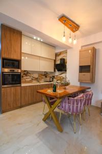 伊莱恩Maria Ireon Apartment 1 with hot-tube的厨房配有木桌和紫色椅子