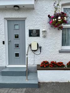 托基宾利旅舍的一座白色的房子,前面有一扇门,鲜花盛开