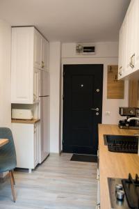 尼普顿Apartament Zeuss Neptun的厨房配有白色橱柜和黑色门