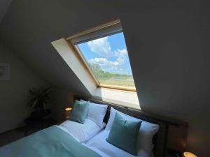 朗斯多夫Pool Sauna Entspannung的卧室配有带枕头的床上方窗户