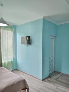 茨卡尔图博Nunu's Guesthouse的蓝色的客房设有床和窗户。