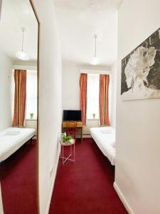 伦敦Orlando hotel的带两张床和镜子的客房